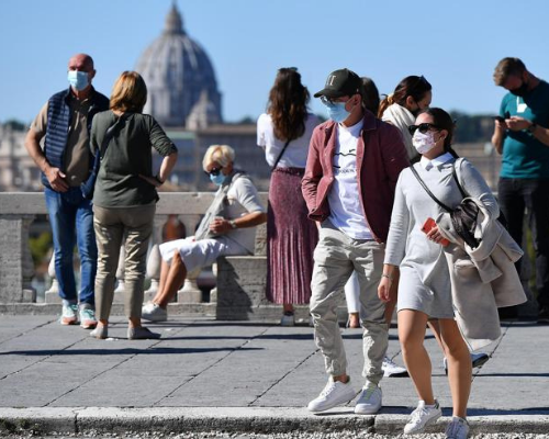 Italiani passeggiano all'aperto con la mascherina e rispettando il distanziamento sociale